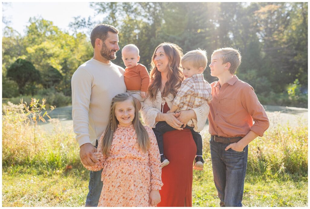 family of six posing near a pond for extended family session outside in Tiffin, Ohio