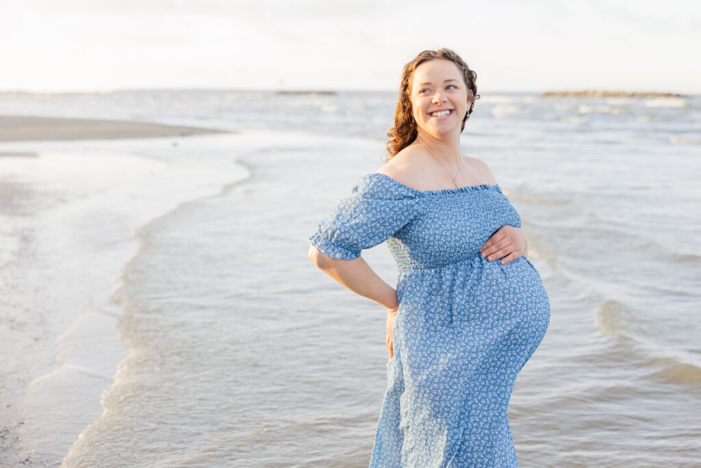 mother to be wearing a blue off shoulder dress at Lake Erie beach maternity session