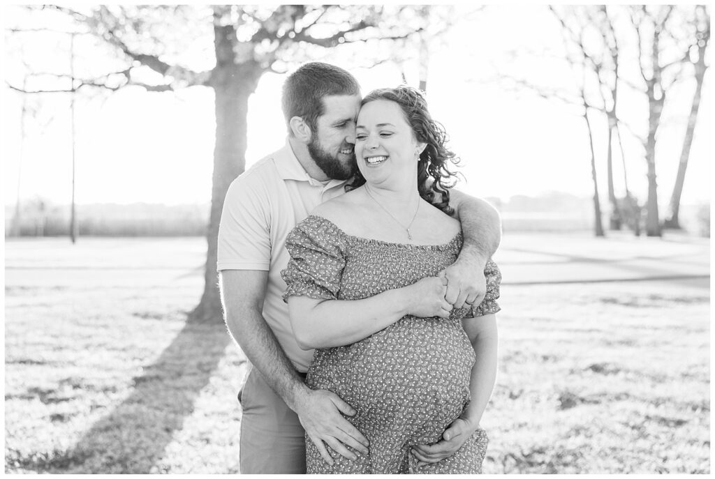 married couple hugging together during Lake Erie maternity session with Fremont, Ohio photographer