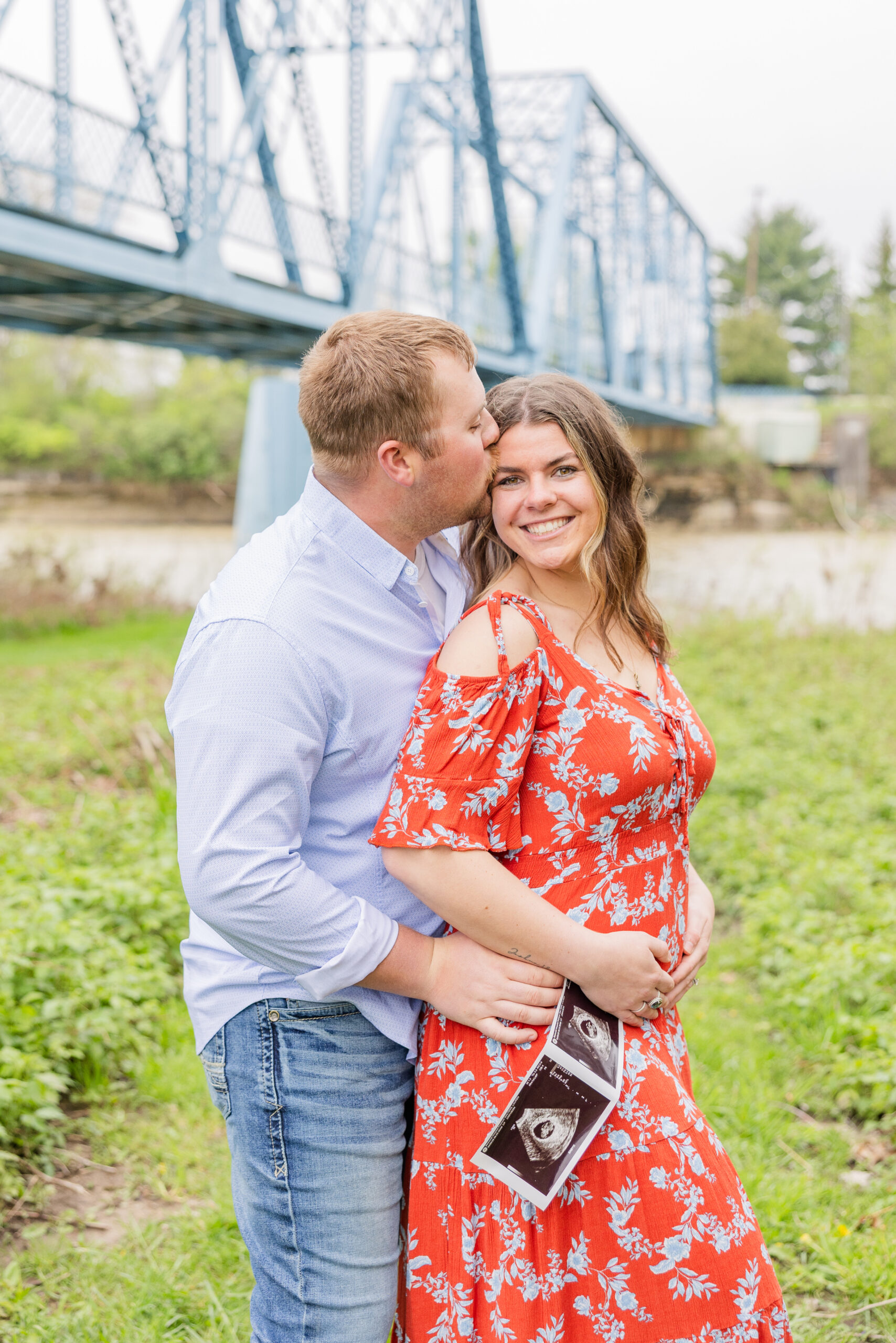 married couple holding their ultrasound near the Tindall Bridge in Ohio