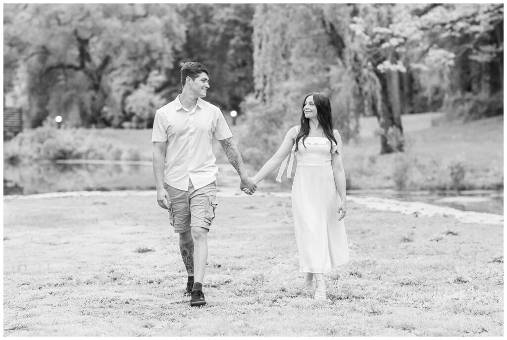 engagement couple holding hands and walking near a pond in Toledo, Ohio